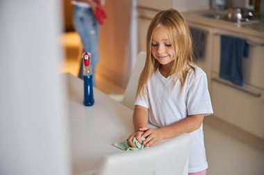 Mutfaktaki beyaz masada duran küçük sevimli kız.