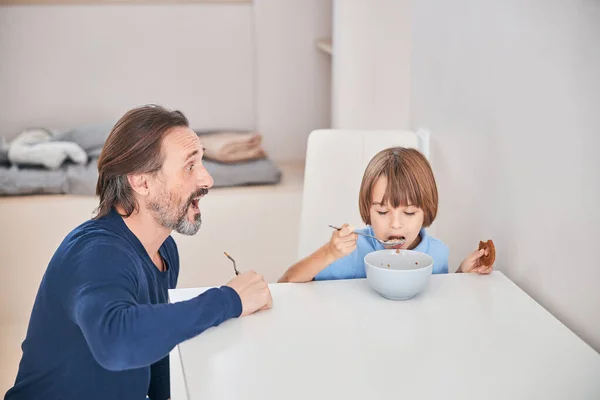 Entusiasta padre animando a su hijo a desayunar — Foto de Stock