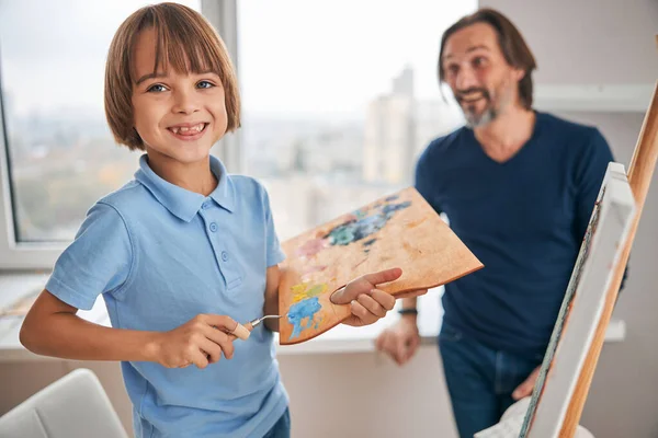 Веселий маленький хлопчик і його тато роблять картину — стокове фото