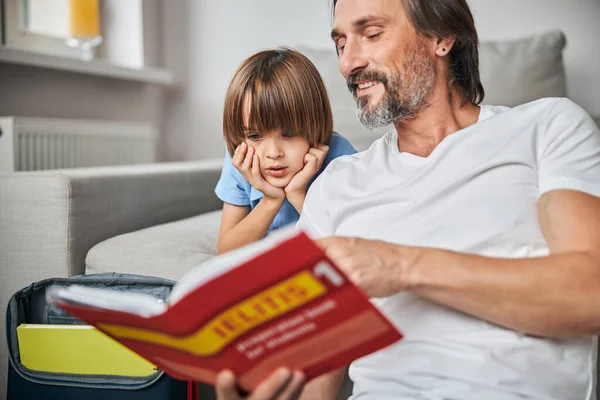 Fürsorglicher Vater hilft seinem Sohn bei den Hausaufgaben — Stockfoto