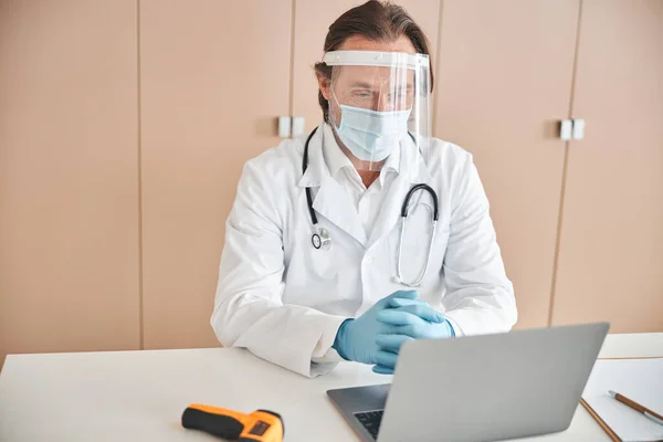 Geconcentreerde medisch medewerker werkt aan zijn laptop — Stockfoto