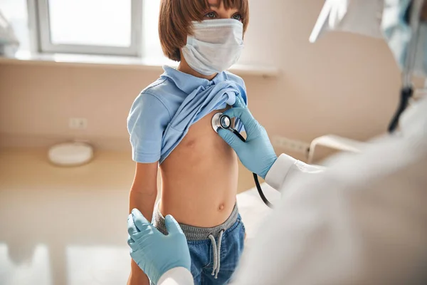 Criança em máscara respiratória com check-up médico — Fotografia de Stock
