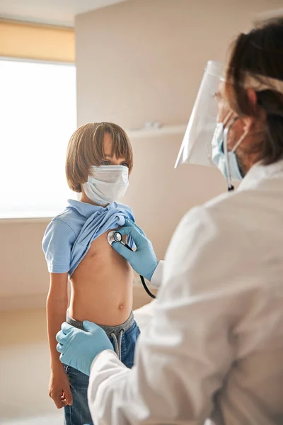 Adorable kid having his respiratory system checked by medic — Stock Photo, Image