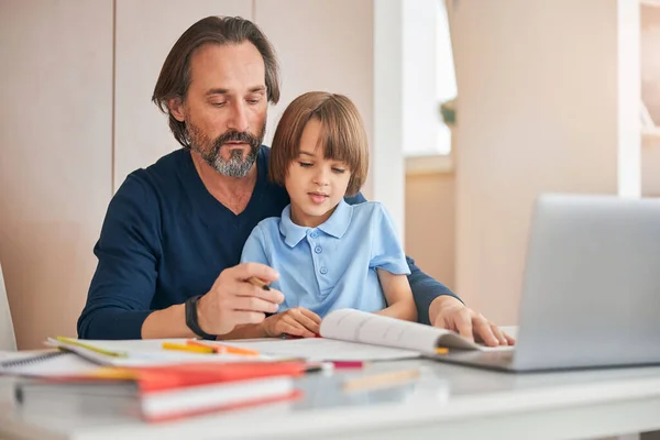 Padre cariñoso ayudando a su hijo a hacer frente a la tarea —  Fotos de Stock