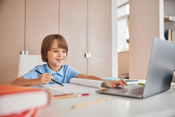 Niño encantador divirtiéndose durante sus lecciones en línea — Foto de Stock