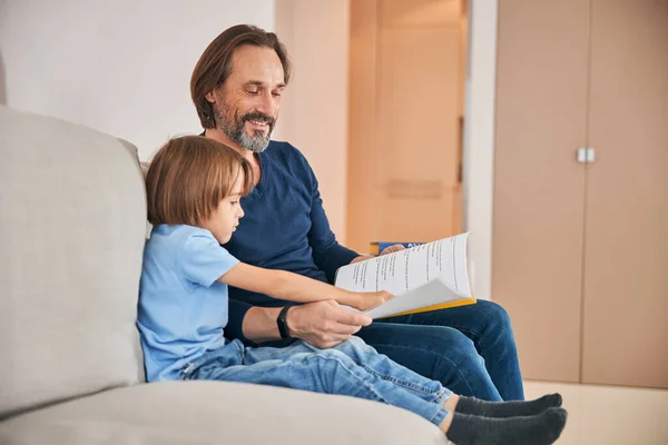 Buona lettura dei genitori a suo figlio a casa — Foto Stock