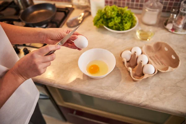 Гострий ніж висить над яйцем — стокове фото