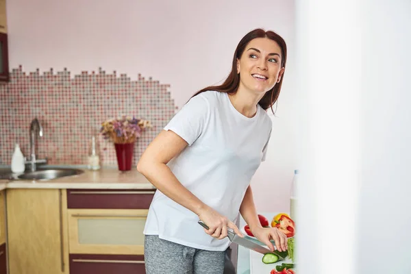 Жінка заглядає з кухні, щоб побачити відвідувача — стокове фото