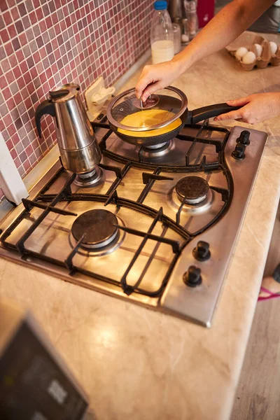 Feminino colocando uma tampa de panela em uma frigideira — Fotografia de Stock