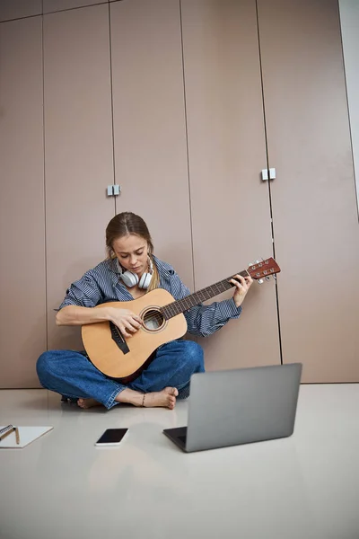 Jovem bonita tocando guitarra em casa — Fotografia de Stock