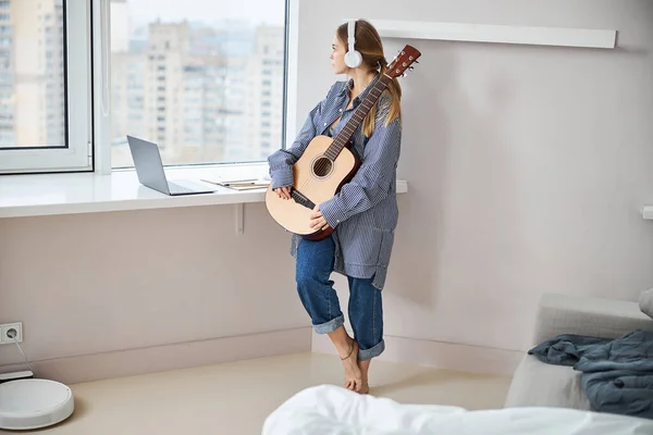 Mulher bonita com guitarra olhando pela janela — Fotografia de Stock