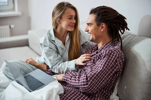 Feliz jovem casal deitado no sofá em casa — Fotografia de Stock