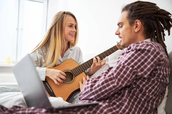 Jovem feliz tocando guitarra e passando tempo com o namorado — Fotografia de Stock