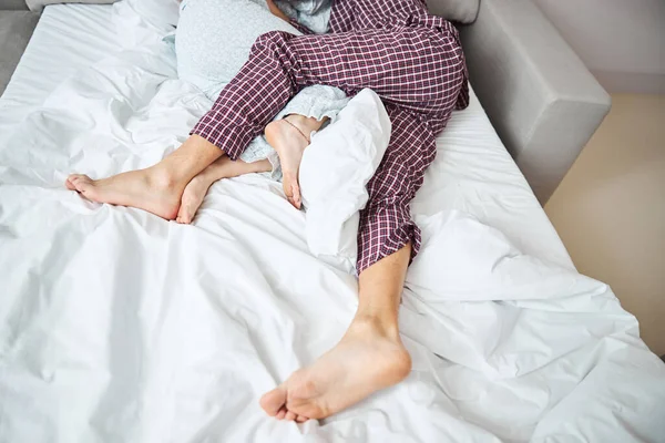 Liefdevol koppel knuffelen en slapen in bed — Stockfoto
