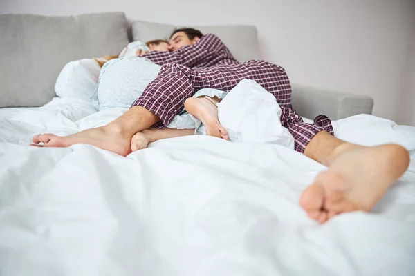 幸福的年轻夫妇睡在床上 — 图库照片