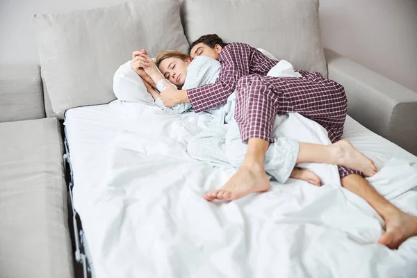 Lyckligt par i kärlek myser och sover i sängen — Stockfoto