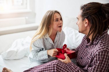 Sevgi dolu genç bir adam, büyüleyici kız arkadaşına hediye veriyor.