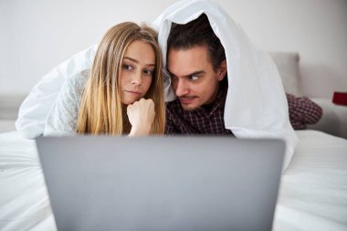 Güzel mutlu çift dizüstü bilgisayarda film izliyor.