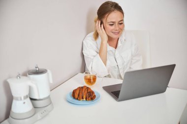 Evinde modern defter kullanan neşeli genç bir kadın.