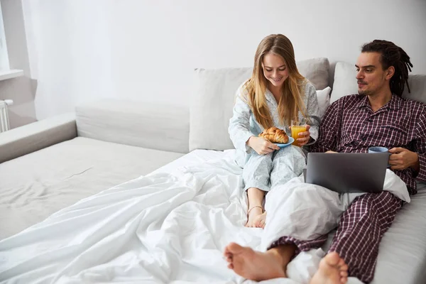 Feliz jovem casal tomando café da manhã na cama — Fotografia de Stock