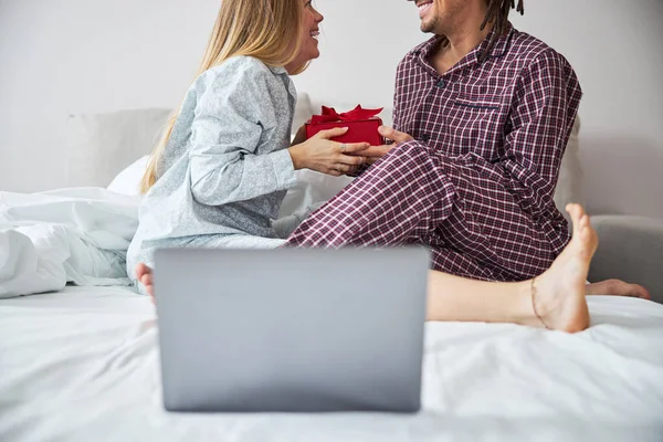 Kärleksfull man ger present till lycklig flickvän i sovrummet — Stockfoto