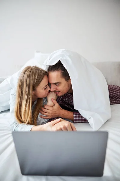 Glada kärleksfulla par kramas och använda laptop hemma — Stockfoto