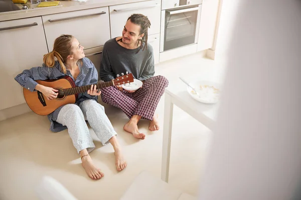 Mulher bonita com guitarra passar tempo com namorado em casa — Fotografia de Stock