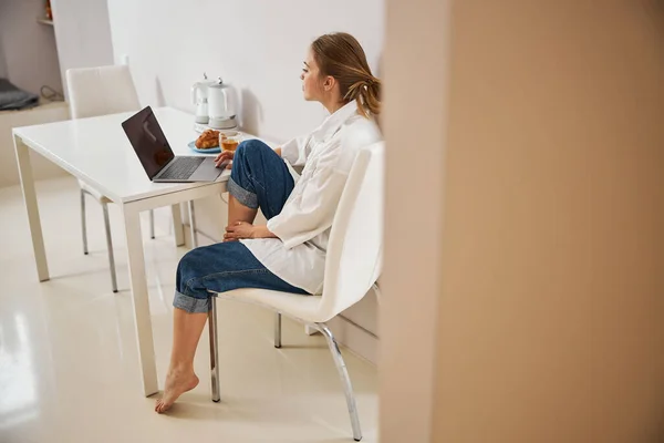 Charmante jeune femme utilisant un ordinateur portable moderne à la maison — Photo