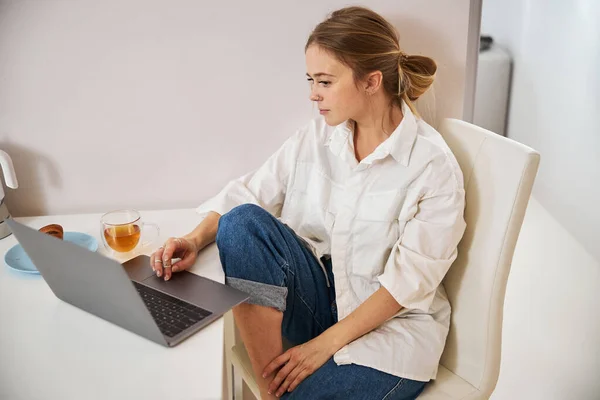 Wanita muda yang menarik menggunakan laptop di rumah — Stok Foto