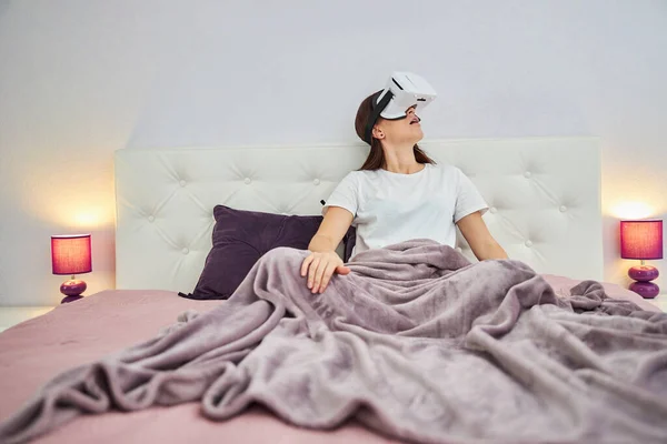 Housewife looking around the room in virtual reality goggles — Stock Photo, Image