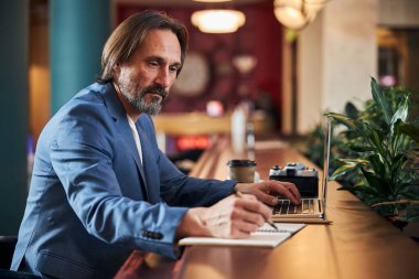 Bir otel odasından uzaktan çalışan özenli iş adamı.