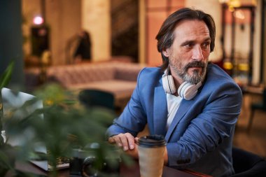 İlgili sakallı beyefendi otel odasında birini bekliyor.