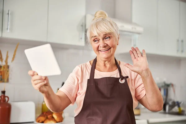 Delightful senior woman having a video-call with loved ones — Stock Photo, Image