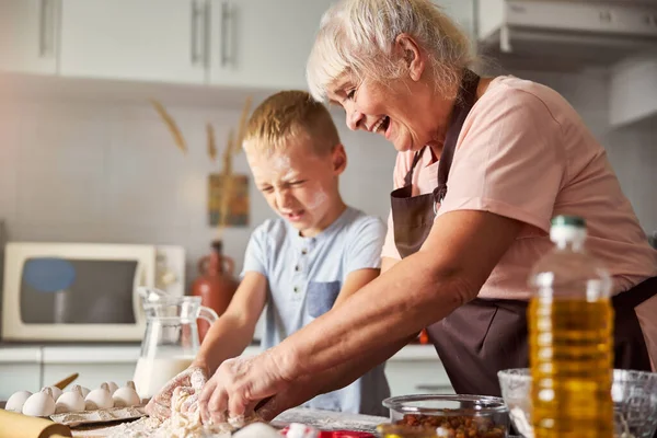 Glada äldre dam och hennes sonson matlagning tillsammans — Stockfoto