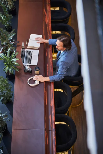 Hombre ocupado instalando equipo de trabajo en el vestíbulo del hotel —  Fotos de Stock