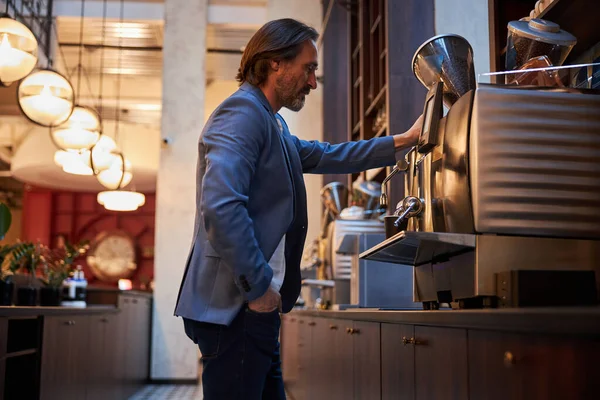 Hombre atractivo tomando café de una máquina de café expreso — Foto de Stock