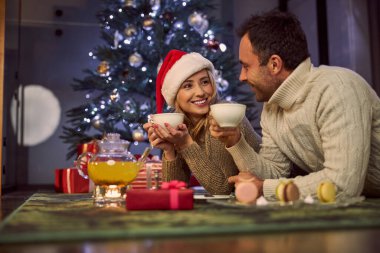 Sıcak çay içen ve kış tatilinin tadını çıkaran sevimli bir çift.