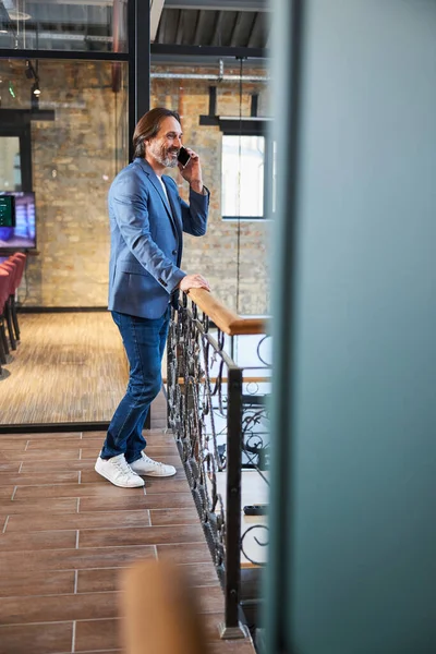 Freundlicher gutaussehender Mann telefoniert aus Hotellobby — Stockfoto