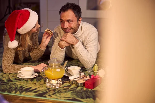 感情的なクリスマスカップルは自宅でケーキとお茶を飲む — ストック写真