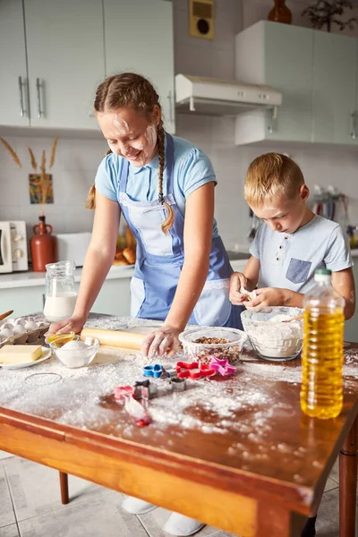 Щасливі брати і сестри намагаються зробити тісто — стокове фото