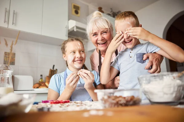 Ritratto di famiglia di nonna e nipoti durante la fabbricazione dei biscotti — Foto Stock