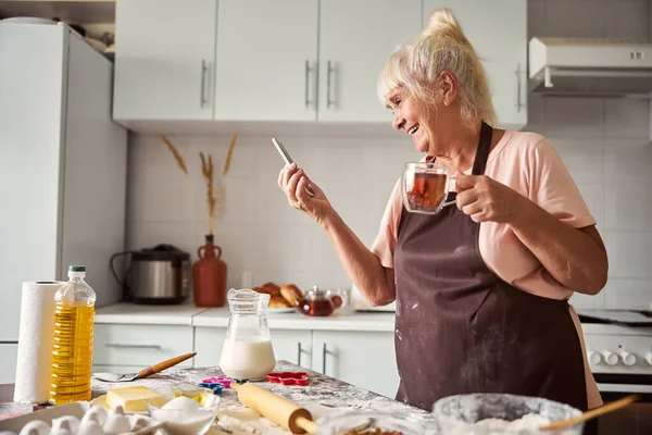 Encantada mujer mayor de vídeo-llamadas a sus seres queridos — Foto de Stock