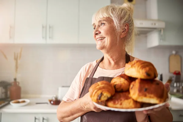 Alegre anciana posando con plato de productos horneados — Foto de Stock