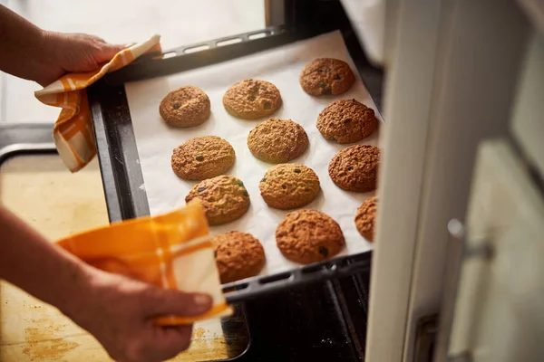 Кваліфікований пекар, який бере сковороду з печивом — стокове фото