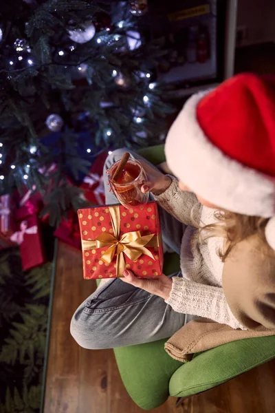 在圣诞树下打开礼物时，穿着保暖衣服，毛毯飘飘然而至的美丽优雅女士 — 图库照片