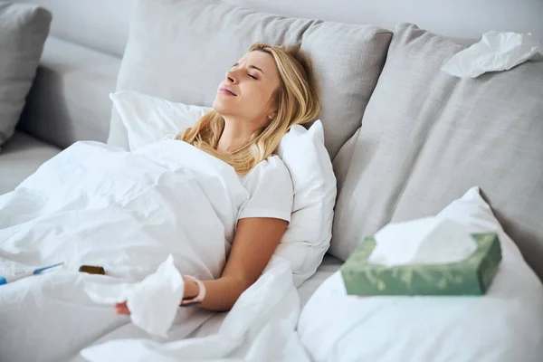 Moe vrouwelijke persoon liggend in haar bed — Stockfoto