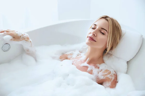 Relaxamento feminino otimista durante o procedimento de tratamento em água — Fotografia de Stock