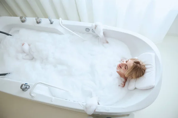 Унылая дама, мечтающая во время отдыха в современной ванной комнате — стоковое фото