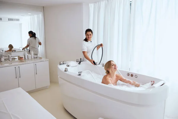 Mulher relaxada desfrutando de hidroterapia enquanto passa um dia no spa de saúde — Fotografia de Stock