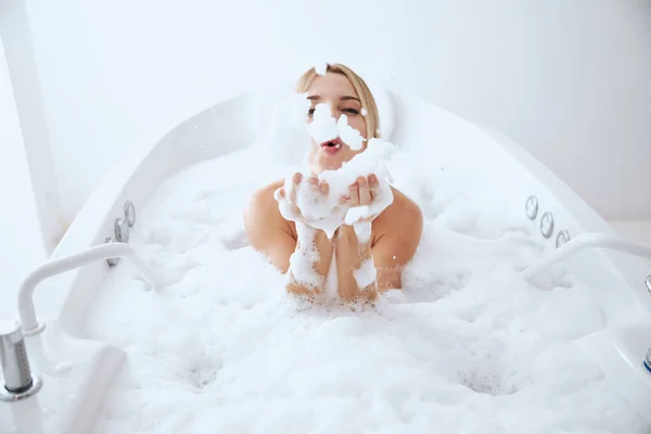 Jovem bela mulher tendo banho de espuma no spa — Fotografia de Stock